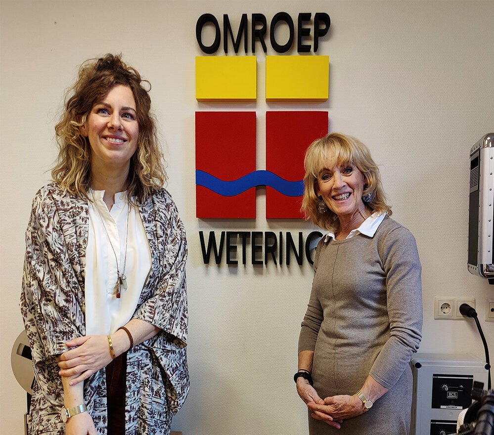 Michèlle en Thera Kokx staan voor het logo van Omroep Wetering