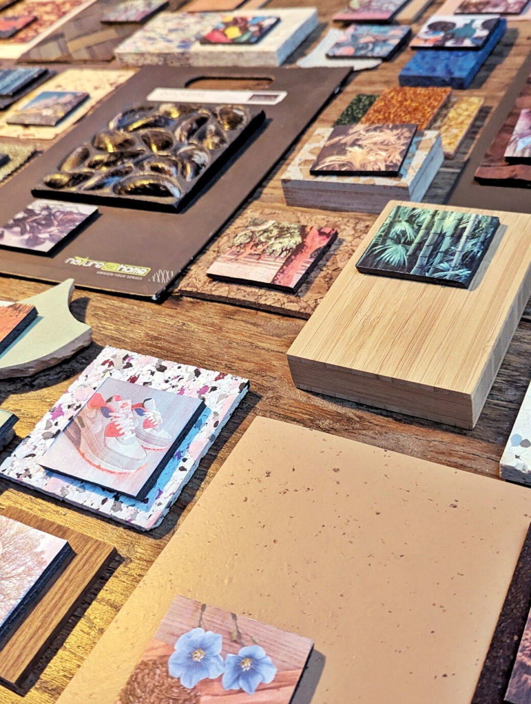 Tafel met stalen van allerlei materialen, zoals een mosselwand en bamboe, met bij elk materiaal een foto van de grondstof