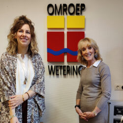 Michèlle en Thera Kokx staan voor het logo van Omroep Wetering
