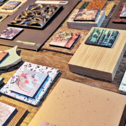 Tafel met stalen van allerlei materialen, zoals een mosselwand en bamboe, met bij elk materiaal een foto van de grondstof